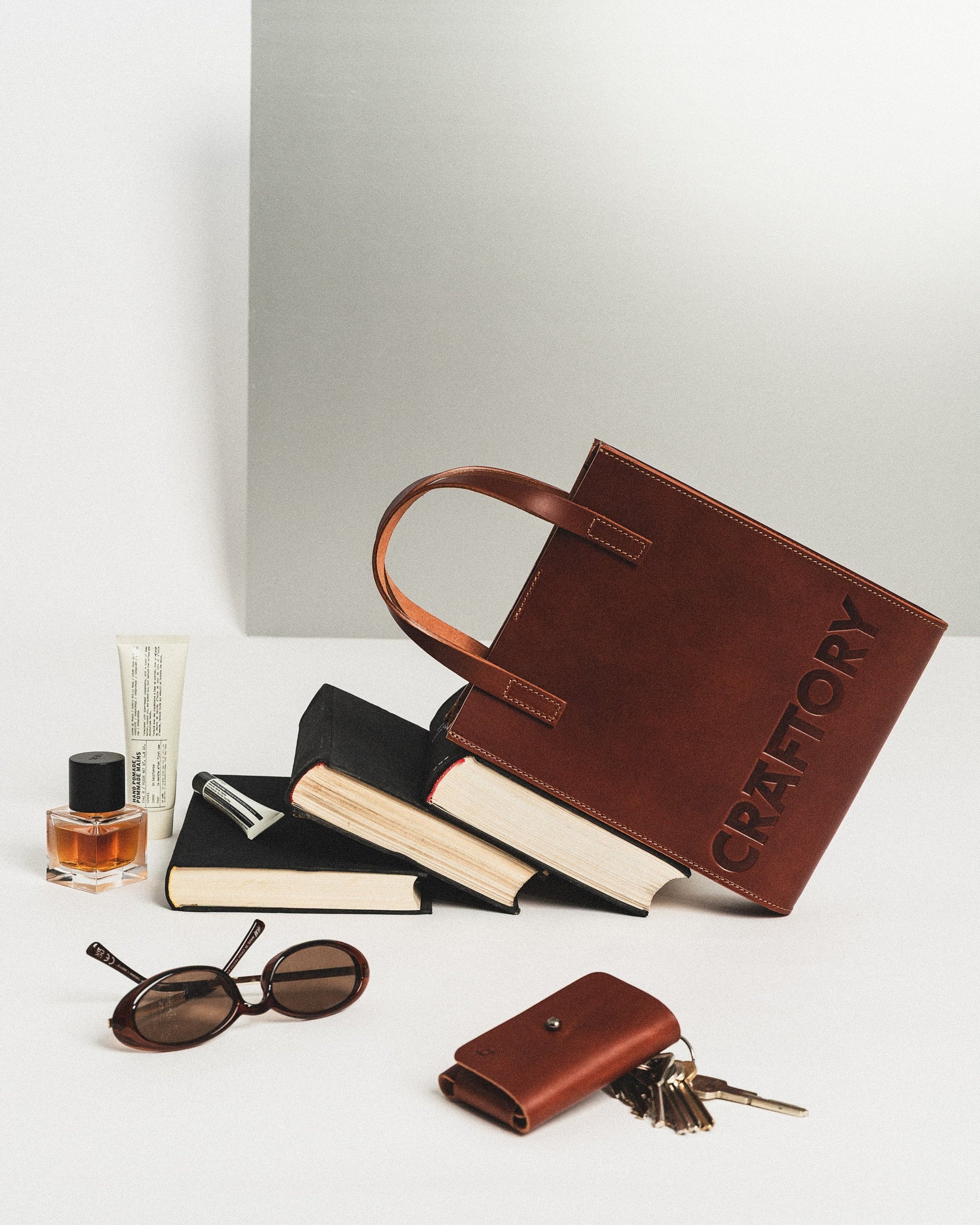 soft cognac leather bucket handbag held gently in warm natural light