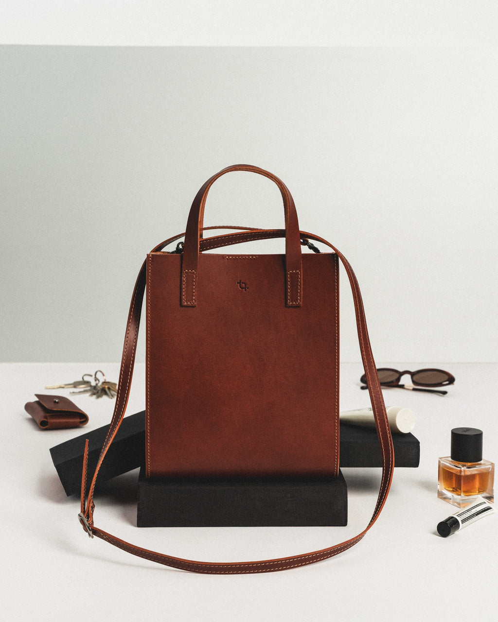 confident woman holding a bold cognac leather bucket bag with top magnetic closure