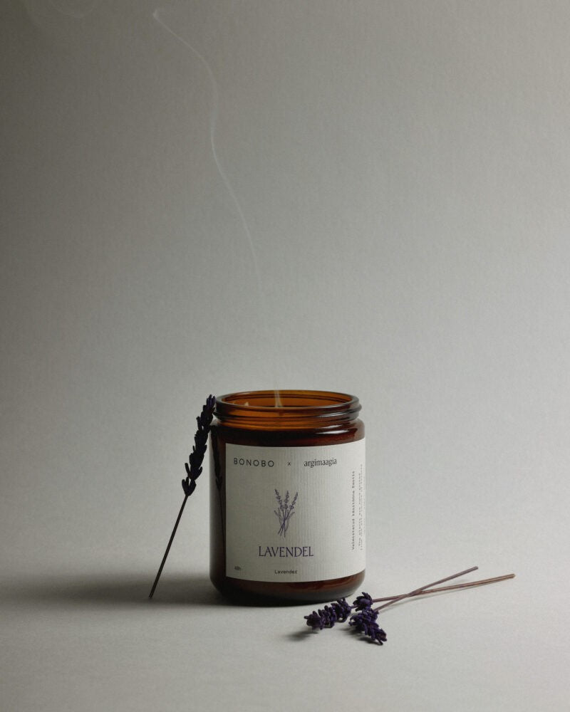 a bold close-up of a handmade lavender soy candle with a long, untrimmed wick