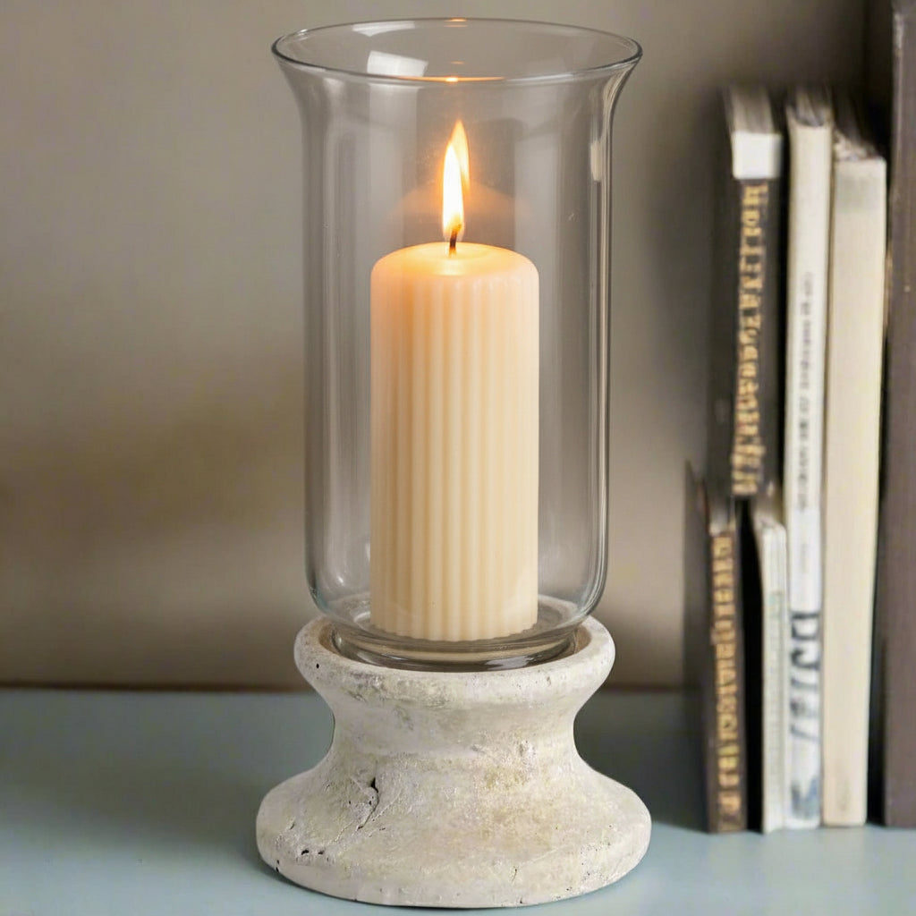 Handcrafted cream hurricane lantern with stone-effect base and antiqued patina, casting warm LED candlelight glow. by sostter at brixbailey.com