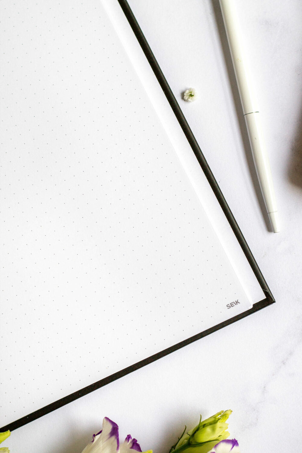 softly lit vegan leather notebook with a comforting texture, open to a dot-grid page
