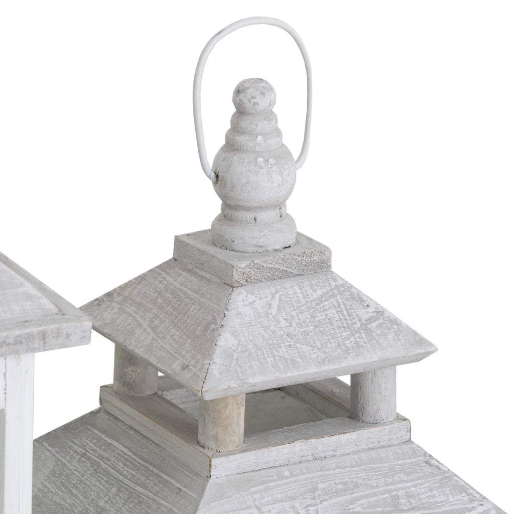 White wooden lantern with intricate window detailing, casting beautiful light patterns for coastal or Scandinavian decor. by RoomLondon at brixbailey.com