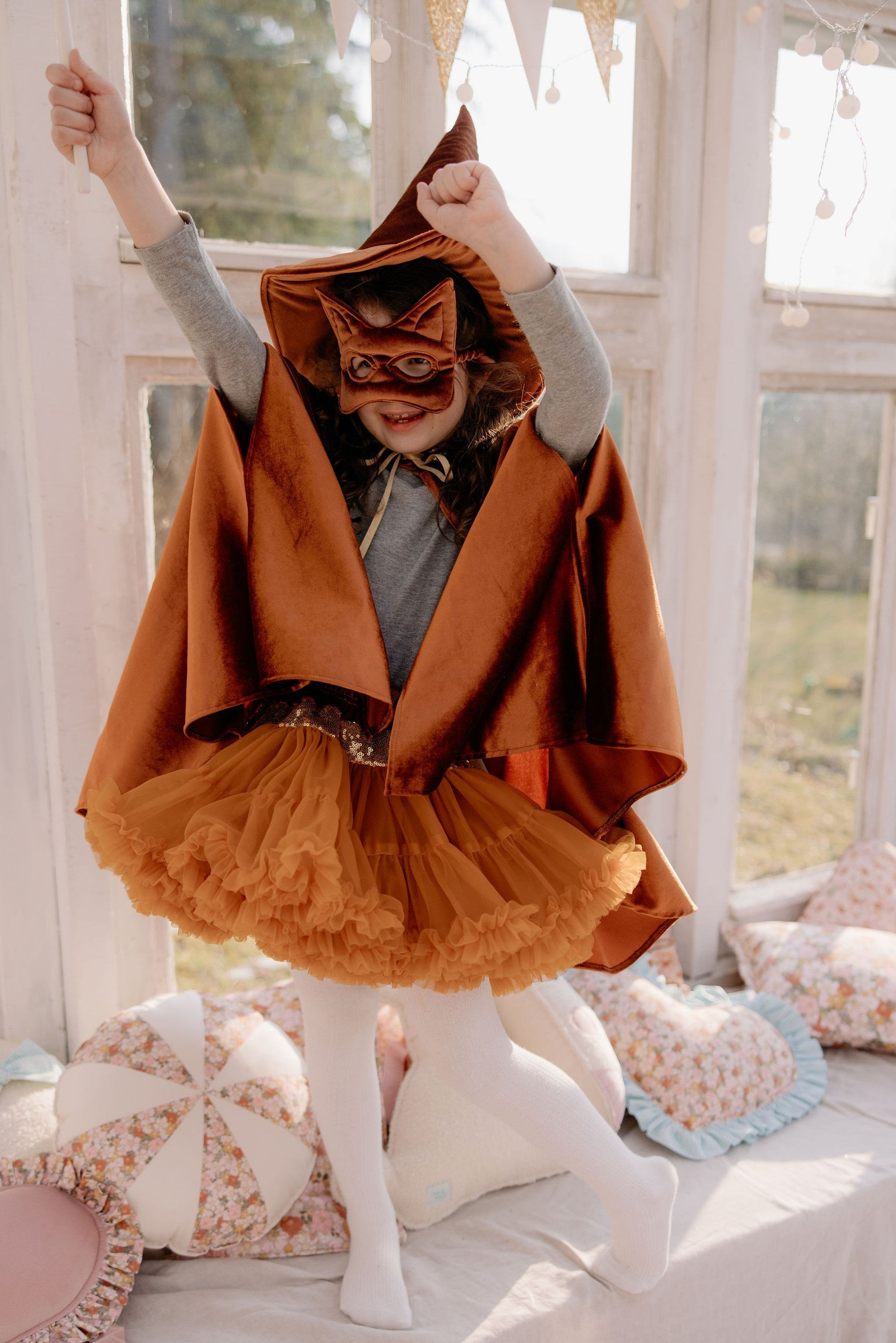 playful ginger cat mask for kids with soft velvet and sequins in warm afternoon light