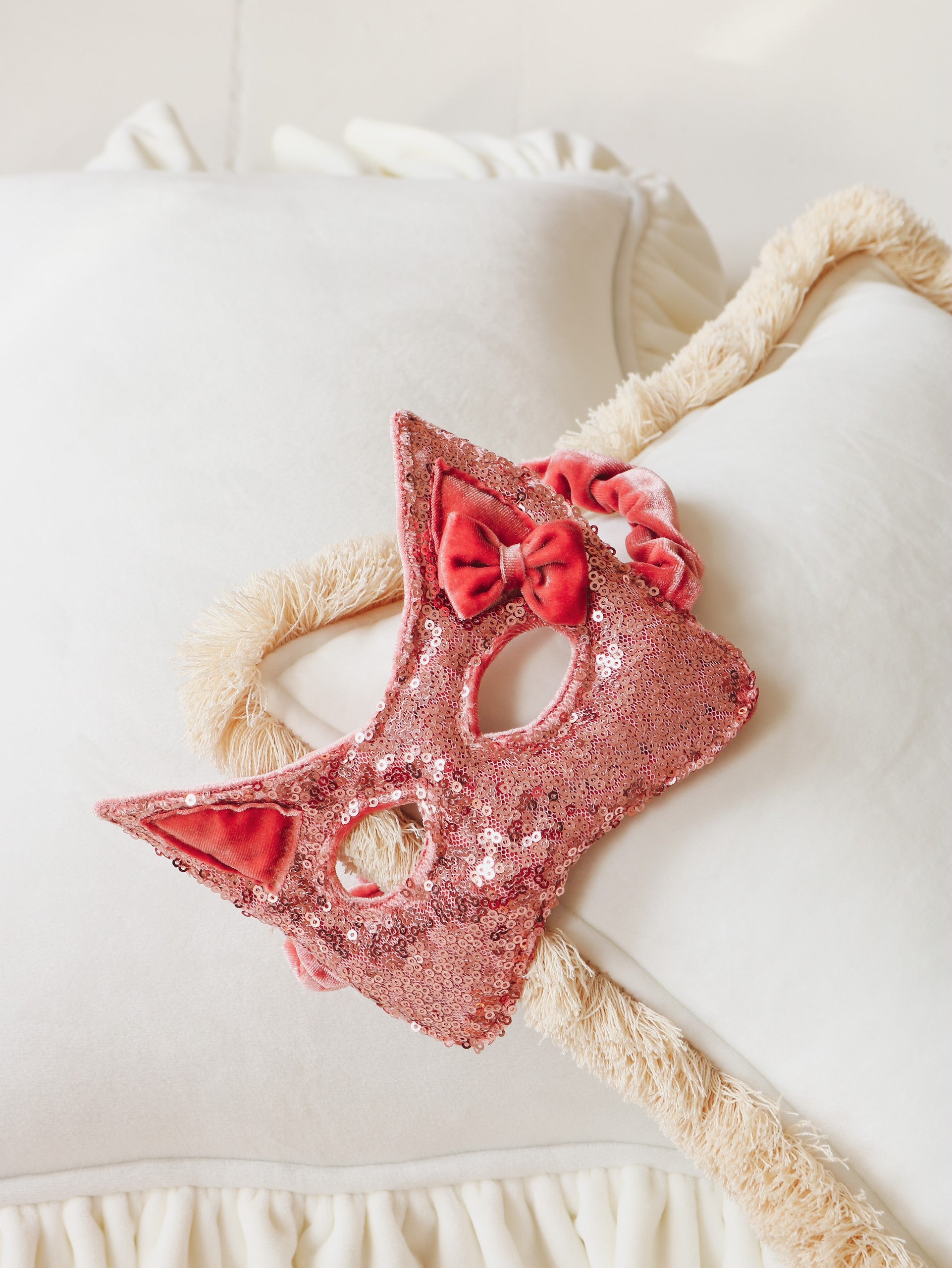 a playful pink sequin cat mask for kids, glowing softly in warm afternoon light during dress-up