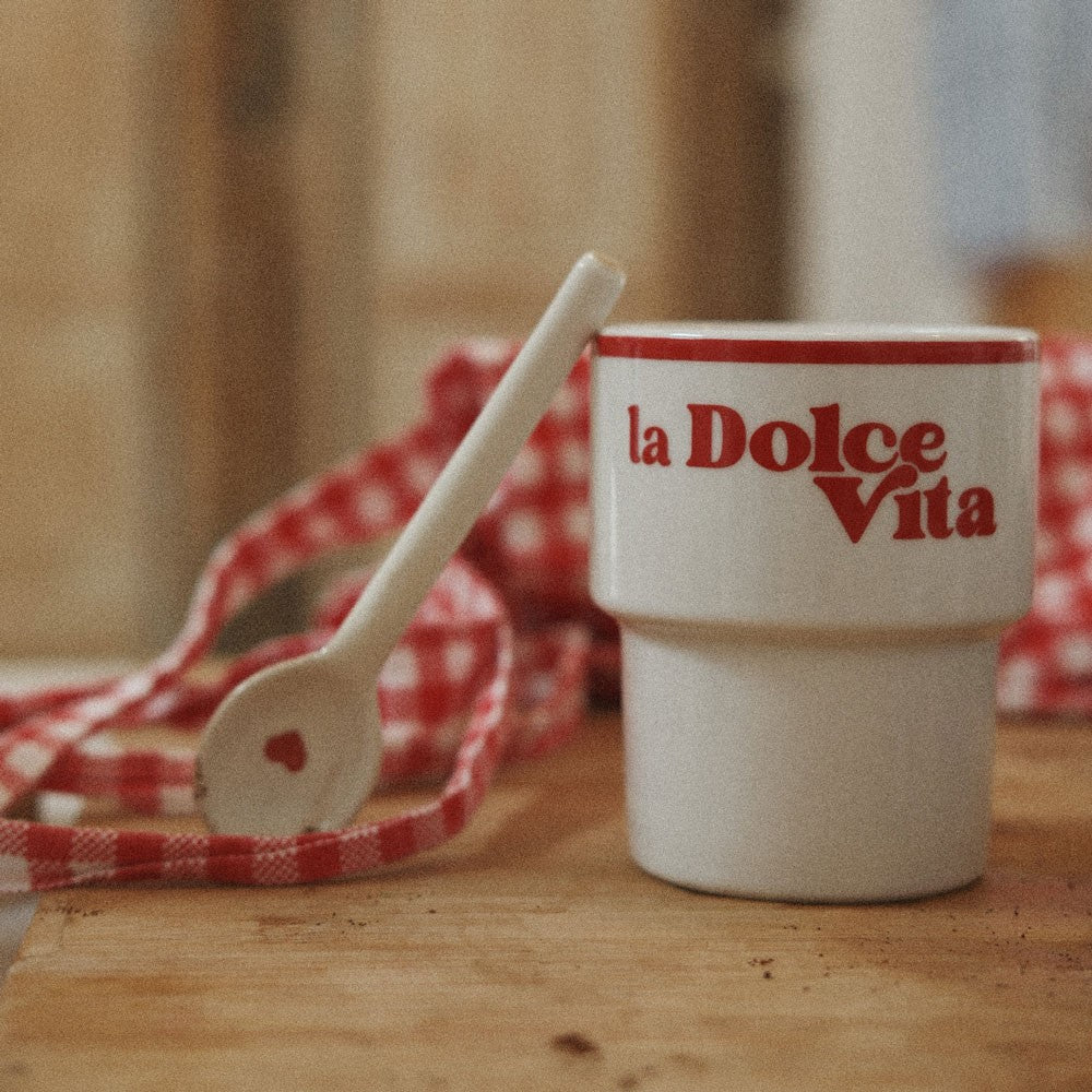 la dolce vita ceramic mug held in hand on a rustic italian cafe table