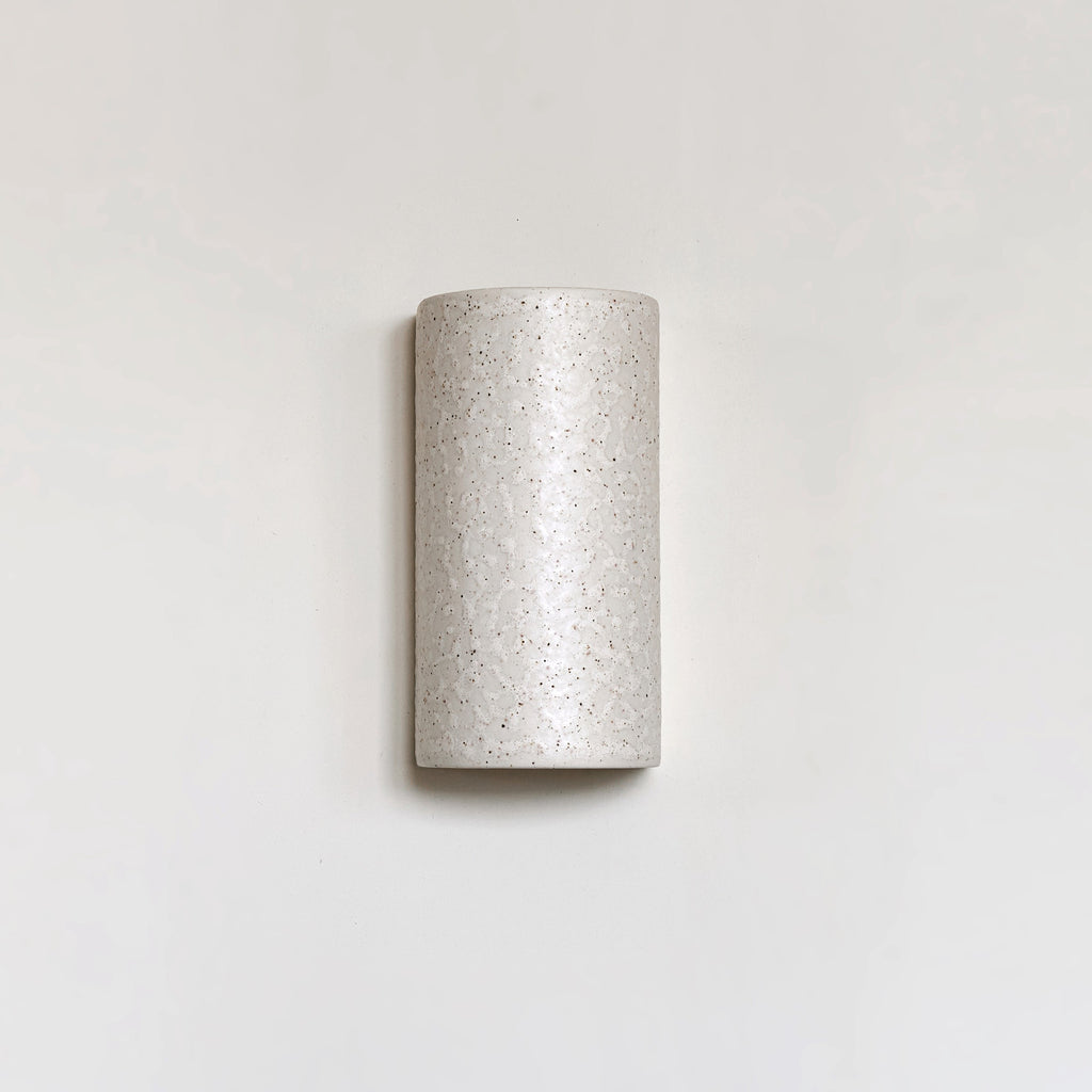elegant beige ceramic wall light with a refined spotted brown glaze, casting a soft glow