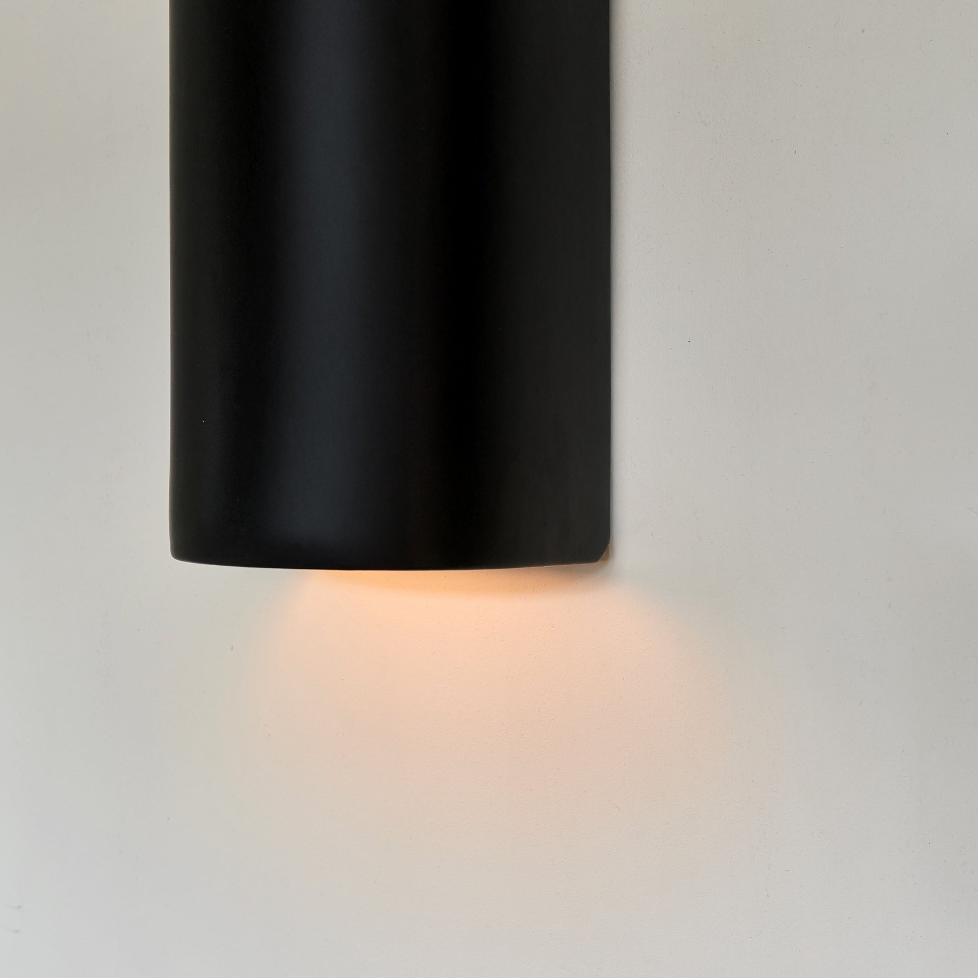 a playful black ceramic wall light casting a fun, cinematic glow in a kids room