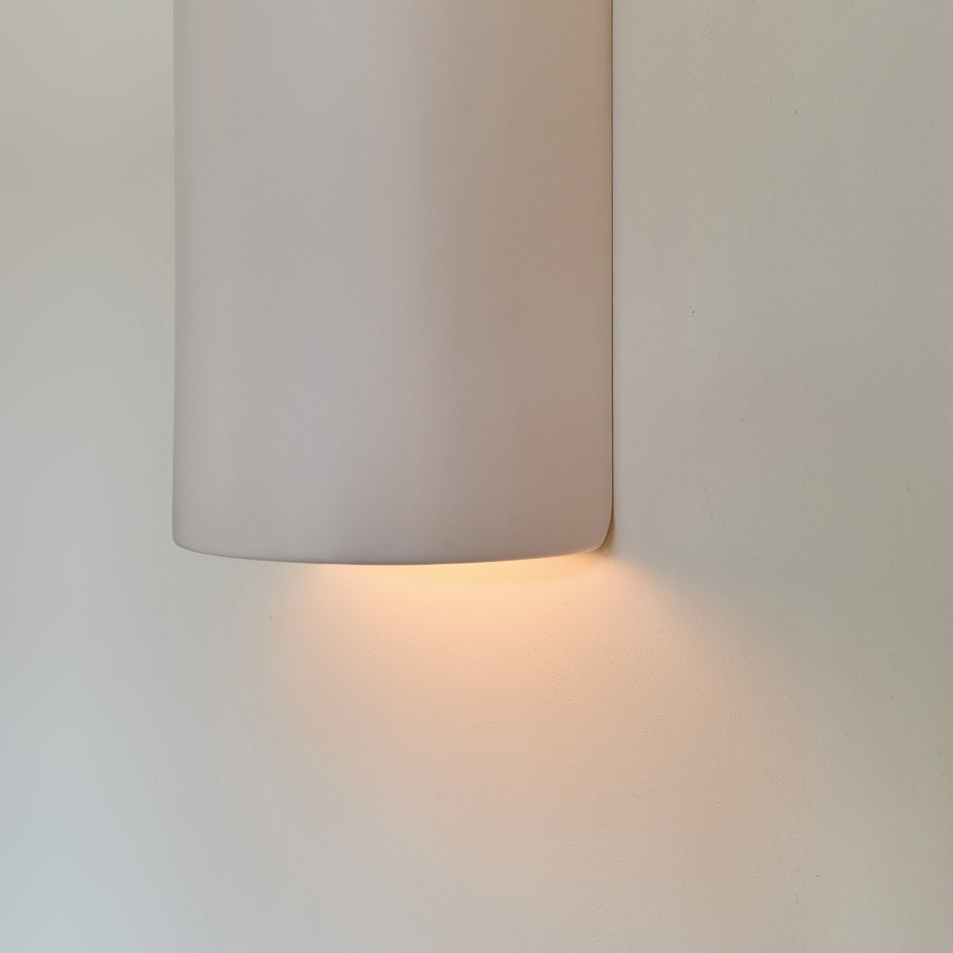 a soft off-white ceramic wall light casting a gentle, comforting glow in a nursery