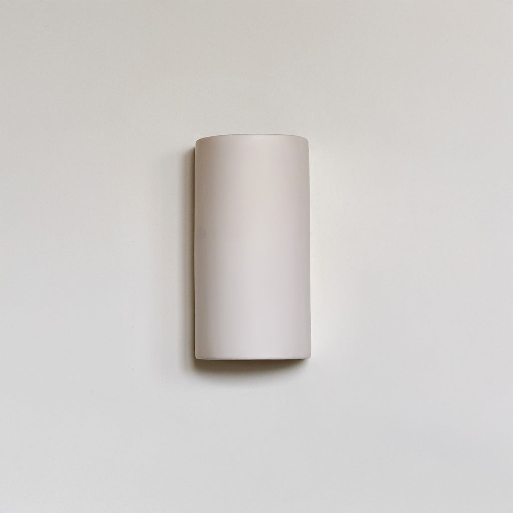 a playful off-white ceramic wall light casting a fun, cozy glow in a kids room