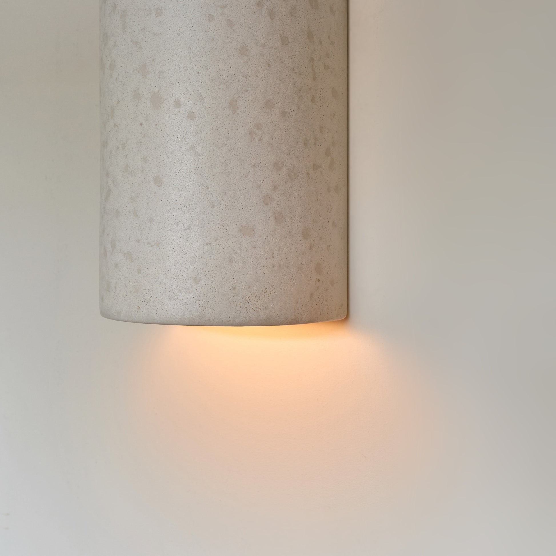 playful raw white ceramic wall light casting a fun glow in a kids room