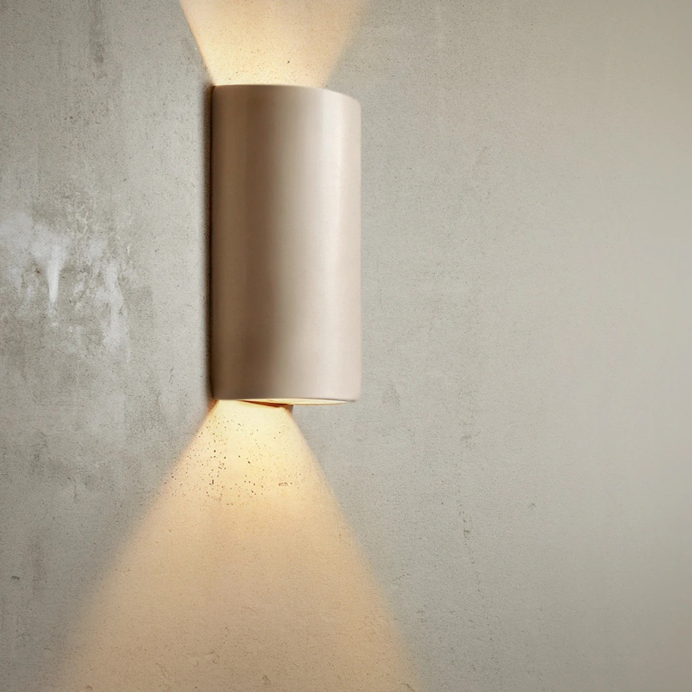 bold taupe ceramic wall light casting a dramatic, sculptural shadow