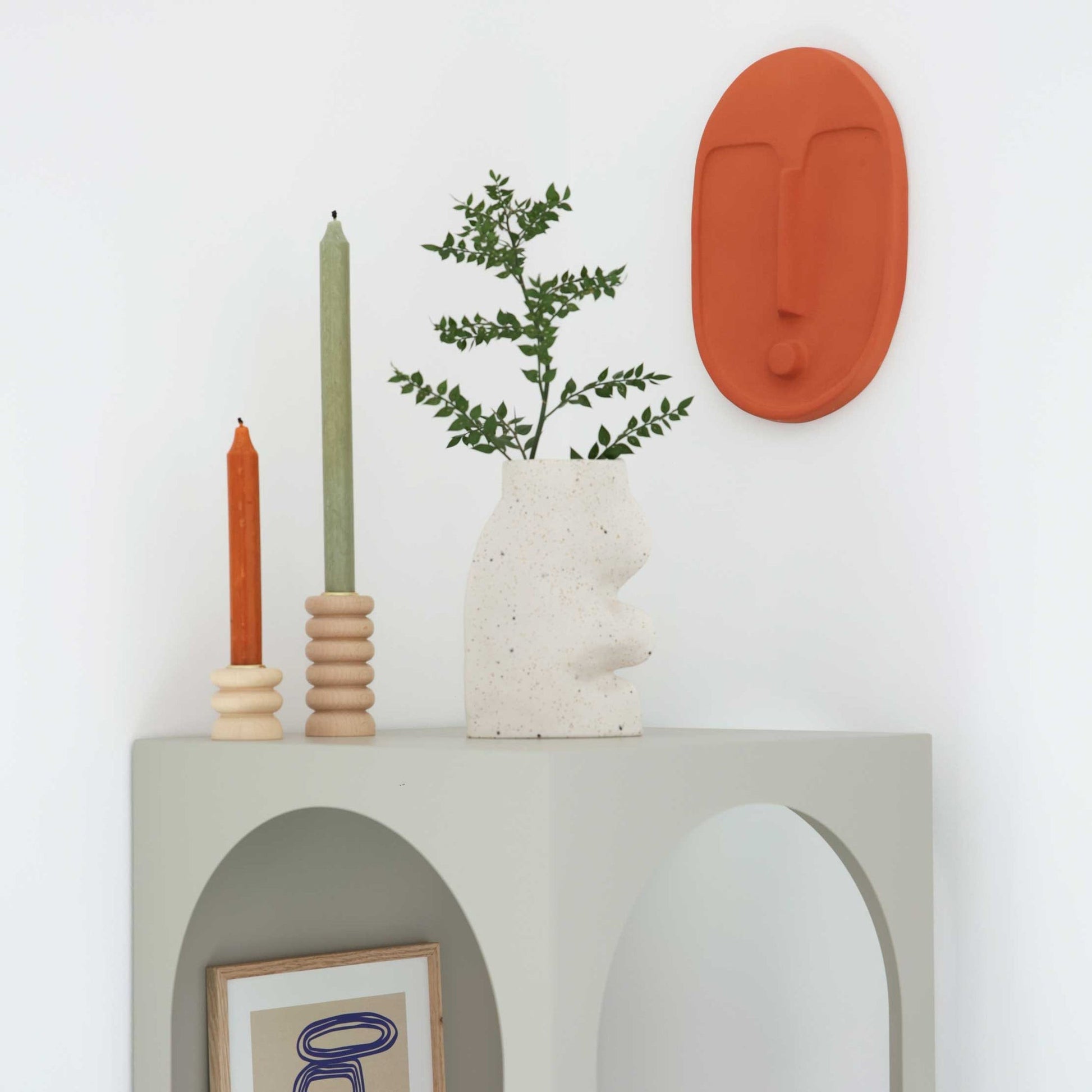 softly lit terracotta wall mask casting a warm, gentle glow on a cozy living room wall