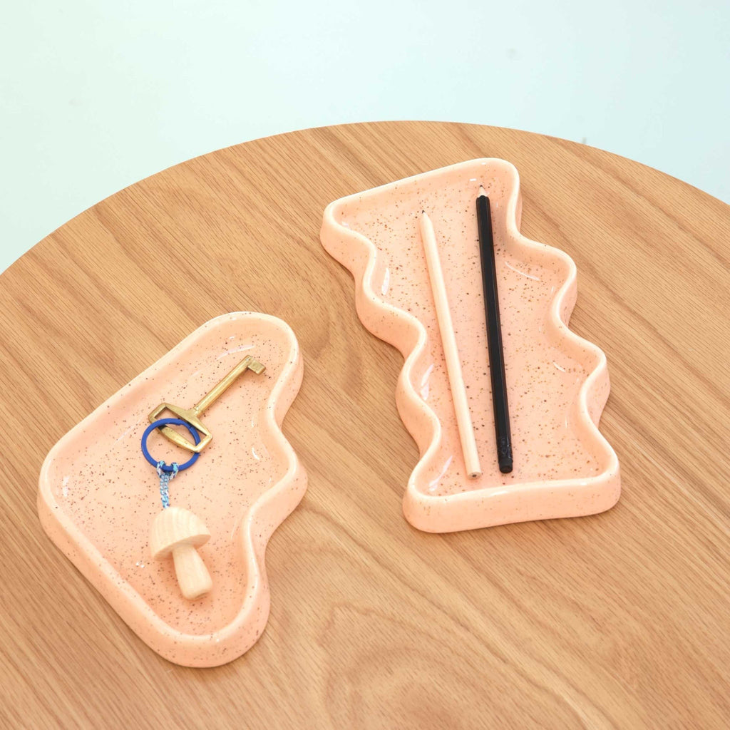 soft peach ceramic wave tray with speckled glaze, resting on a cozy linen surface, perfect for small treasures