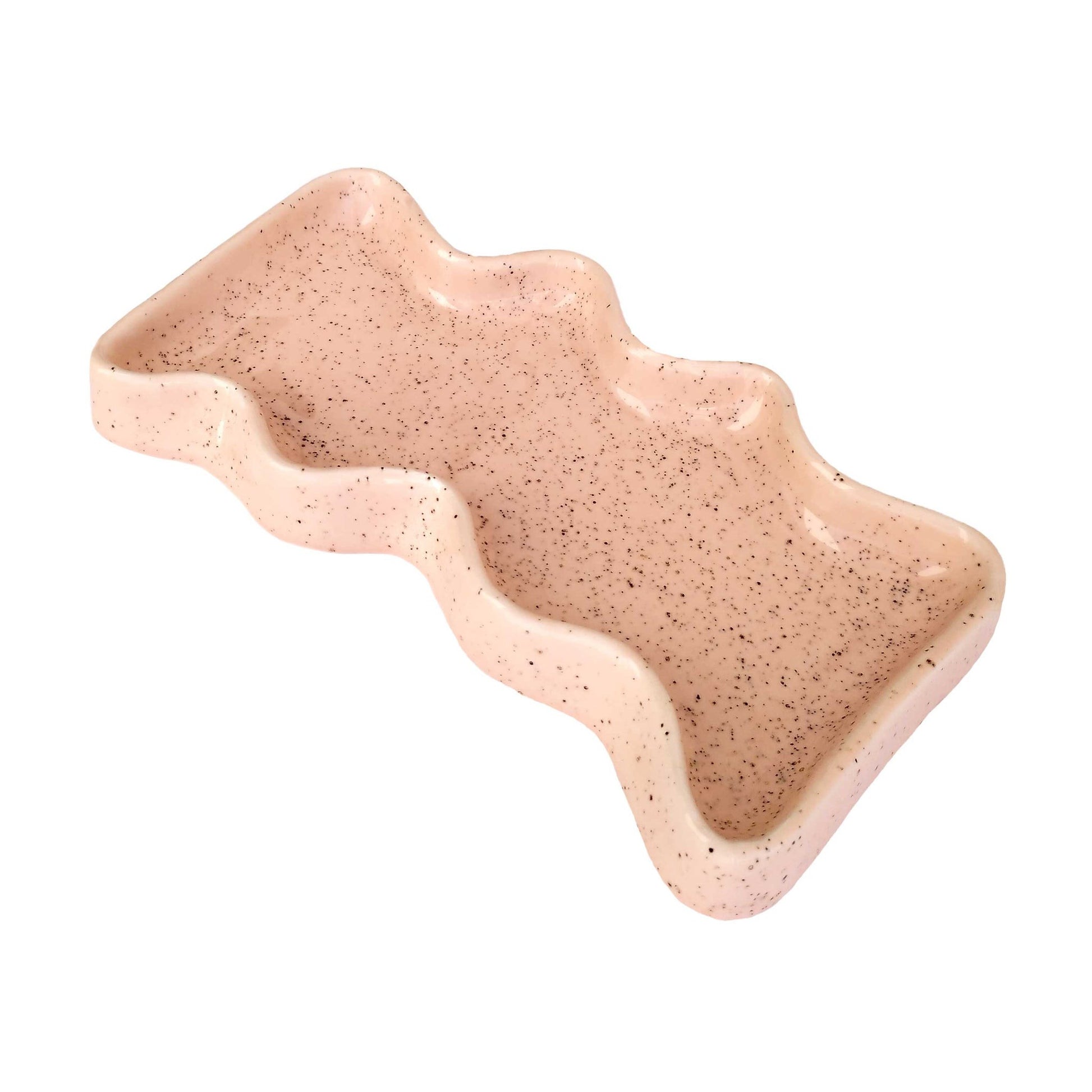 softly lit ceramic wave tray with a comforting peach speckle resting on a linen surface