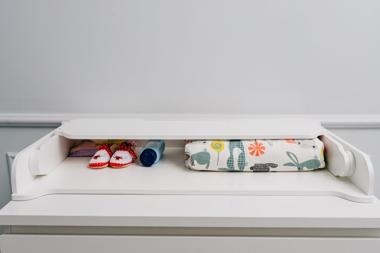 playful birch changing table top on a colorful nursery dresser