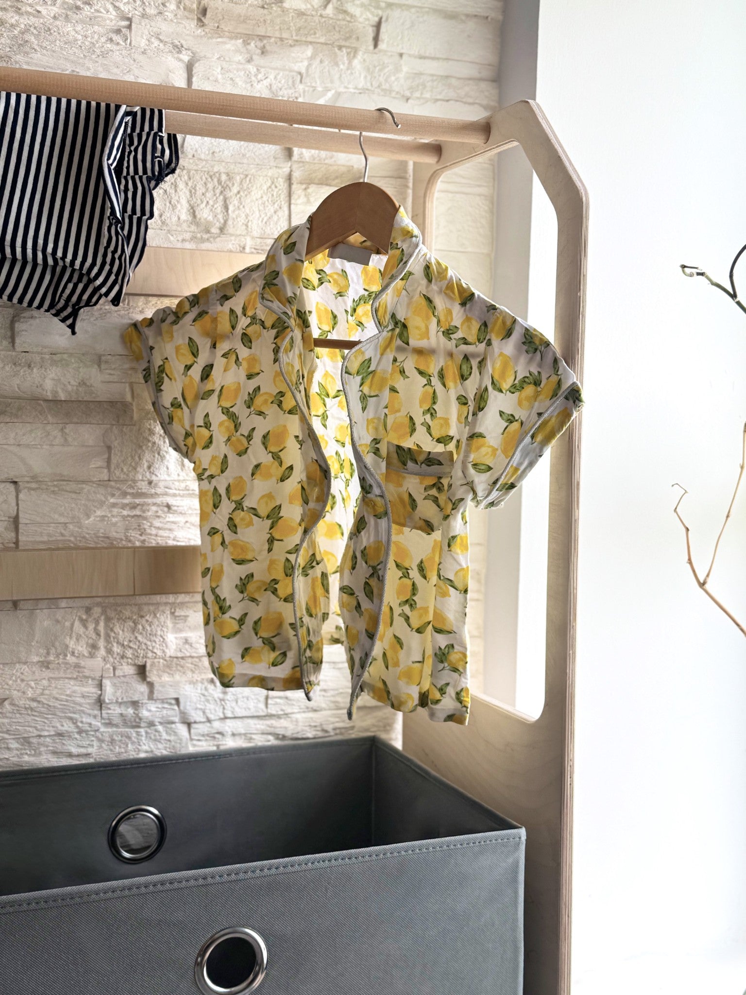 a child's montessori drying rack with a grey fabric basket in a soft, natural morning light