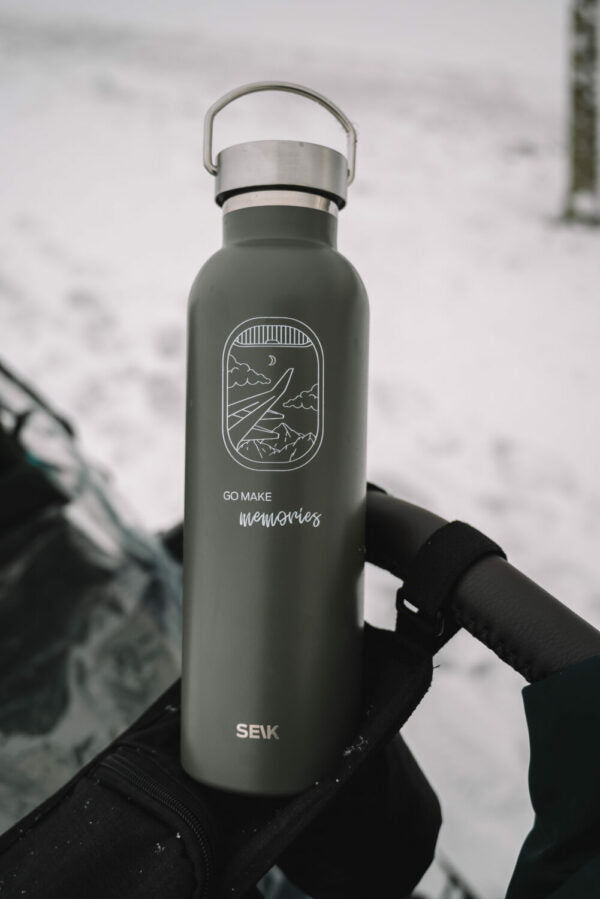 bold black adventure thermos on a rocky mountain trail at sunrise