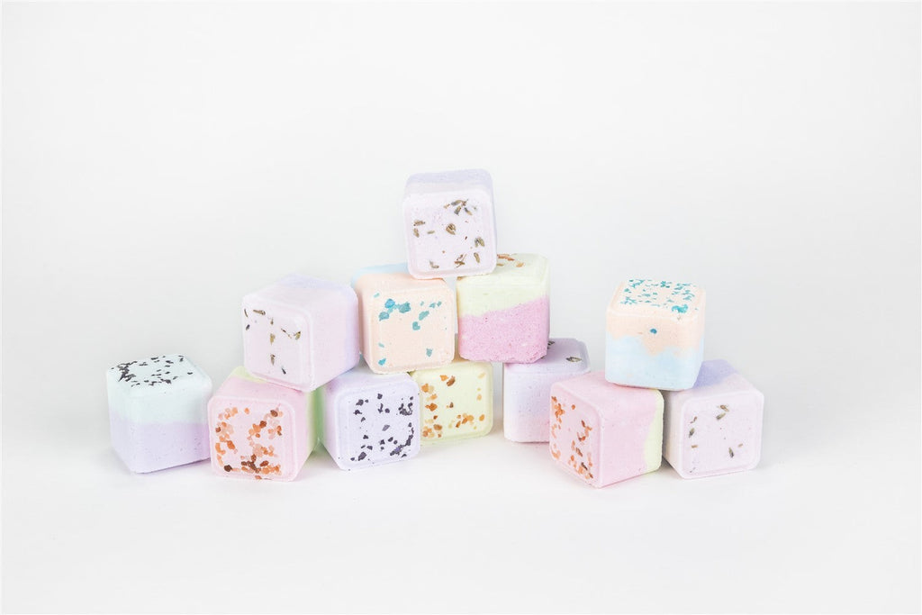 playful celebration gift box with grapefruit bath bomb and white candy on a vibrant towel