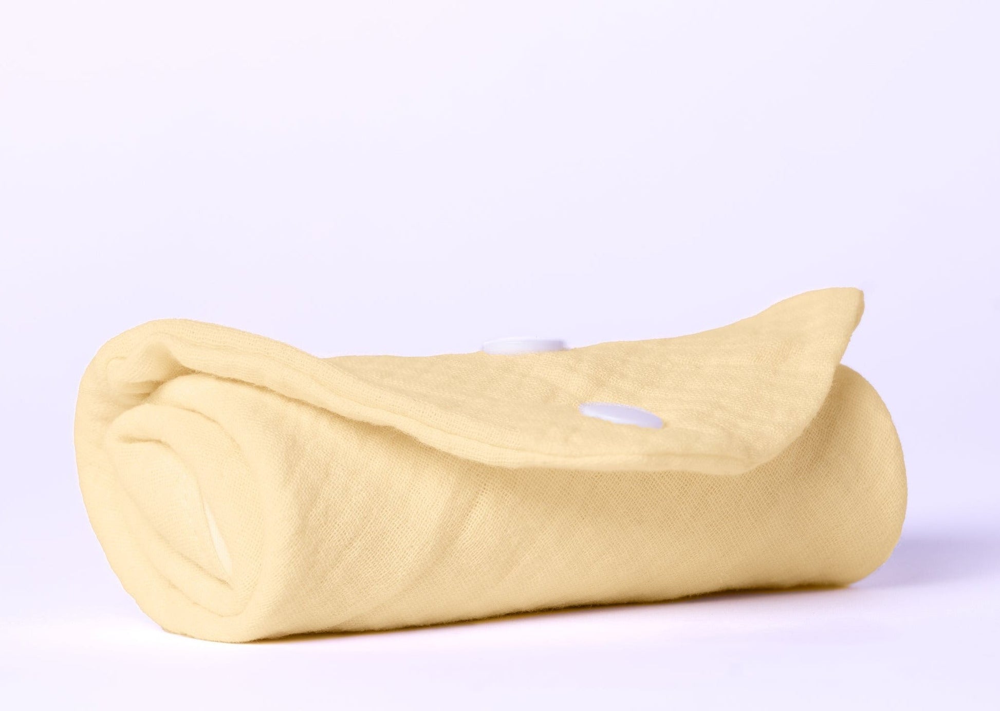 softly lit organic baby gift set with dribble bib and balms arranged on a cozy textile