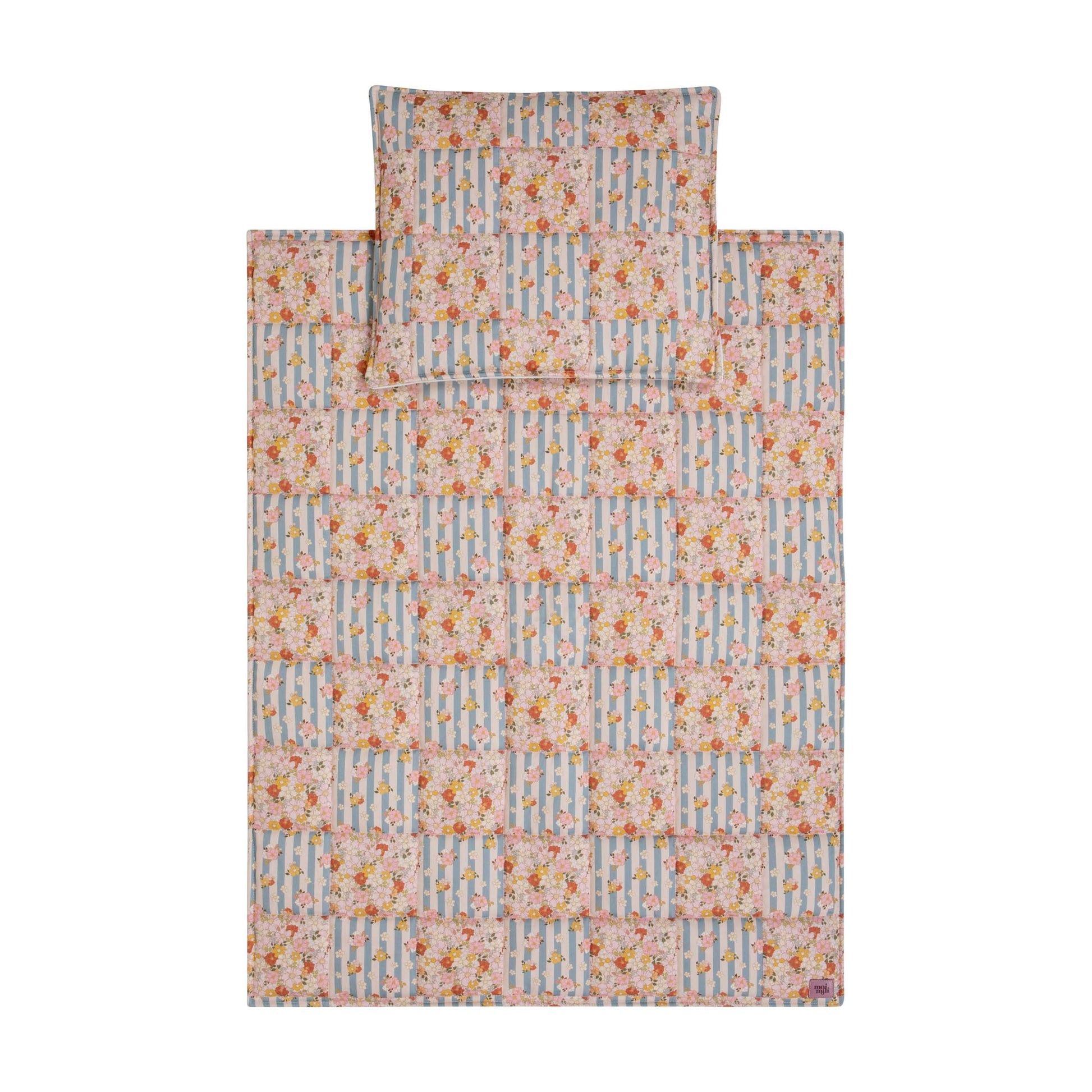 elegant summer garden quilted blanket and pillow set with delicate patchwork on a neutral linen backdrop