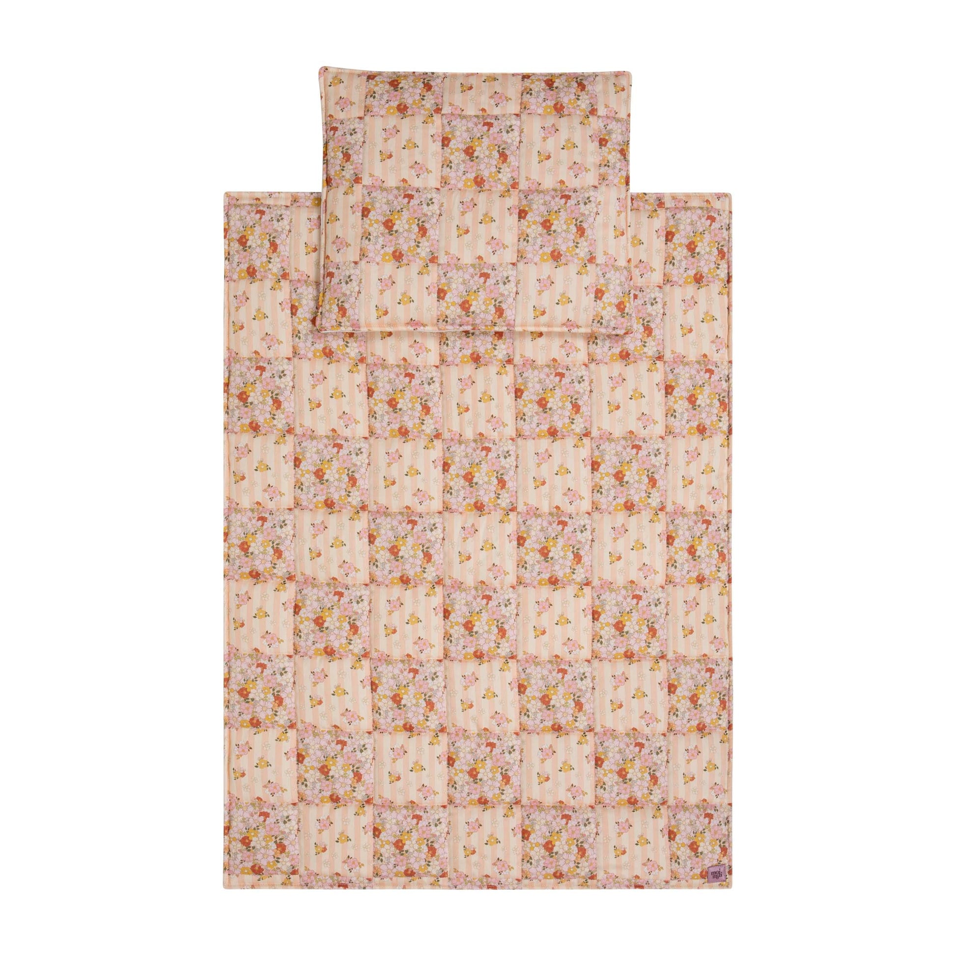 soft cotton quilted blanket and pillow set in spring garden print, draped gently over a wooden rocking chair