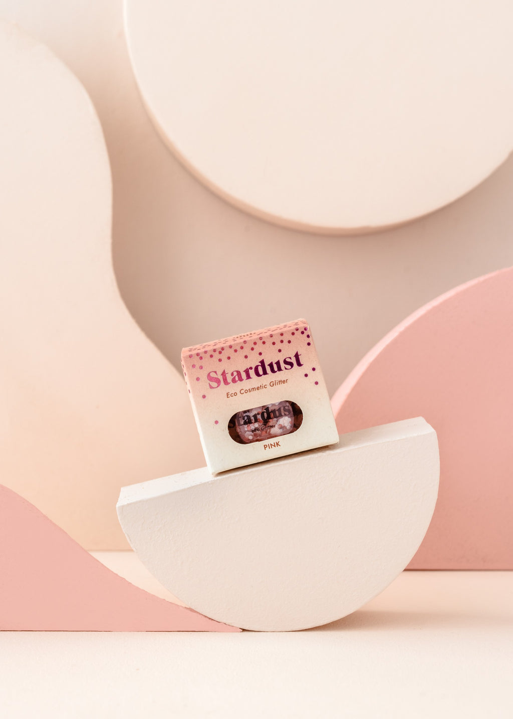 elegant pink star dust glitter in a glass jar on a marble surface