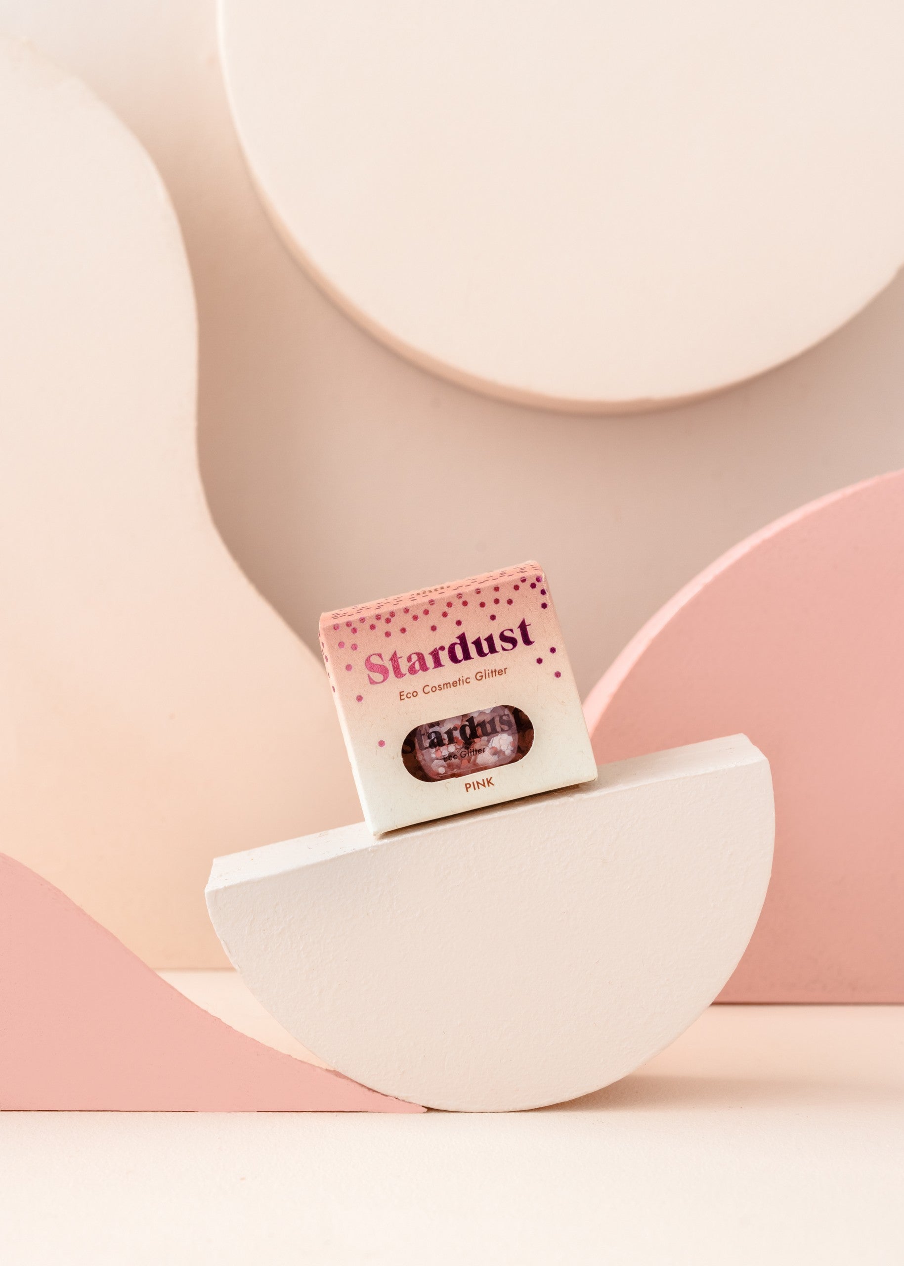 elegant pink star dust glitter in a glass jar on a marble surface