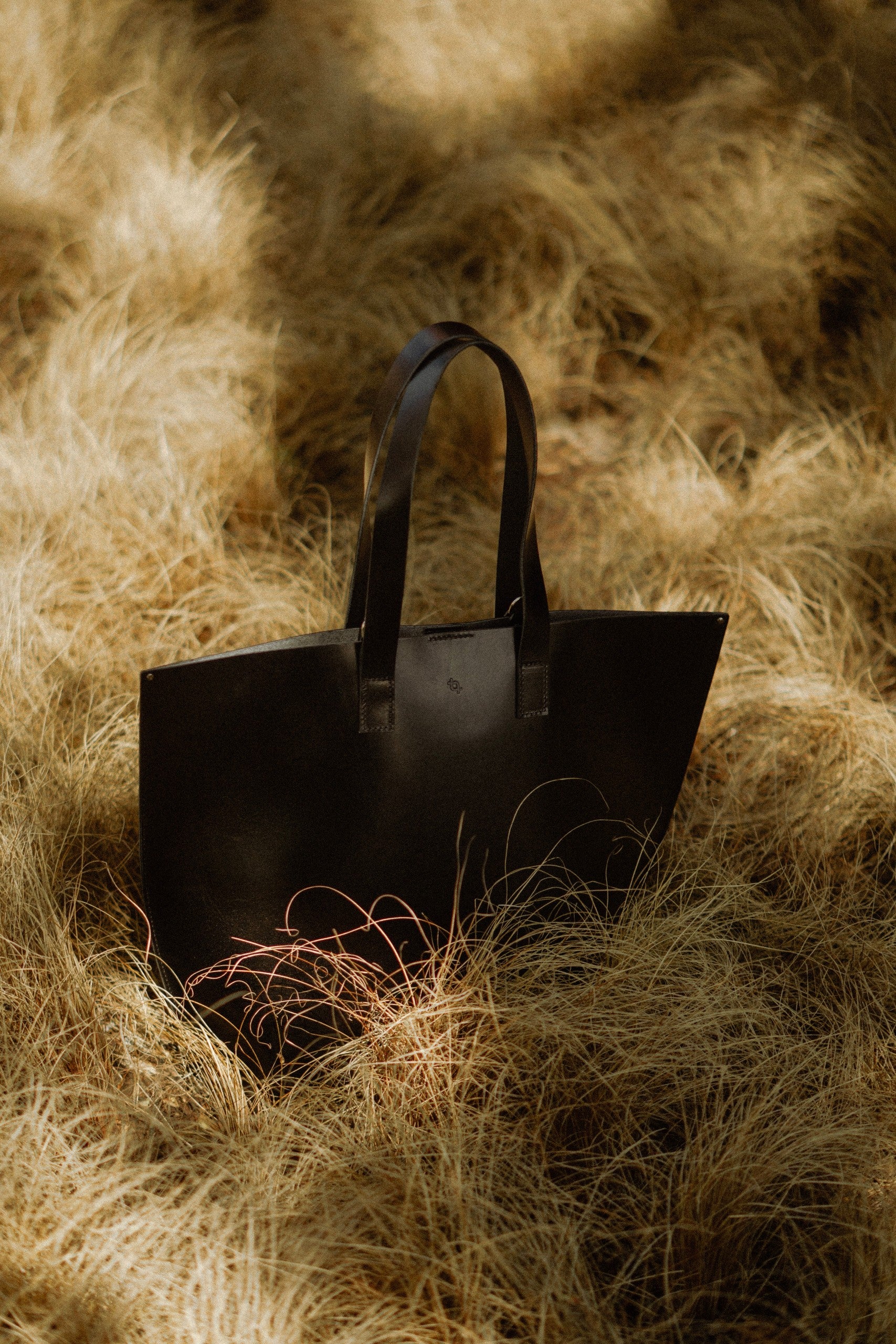 a playful shot of the chic black bucket bag with its adjustable strap swinging freely