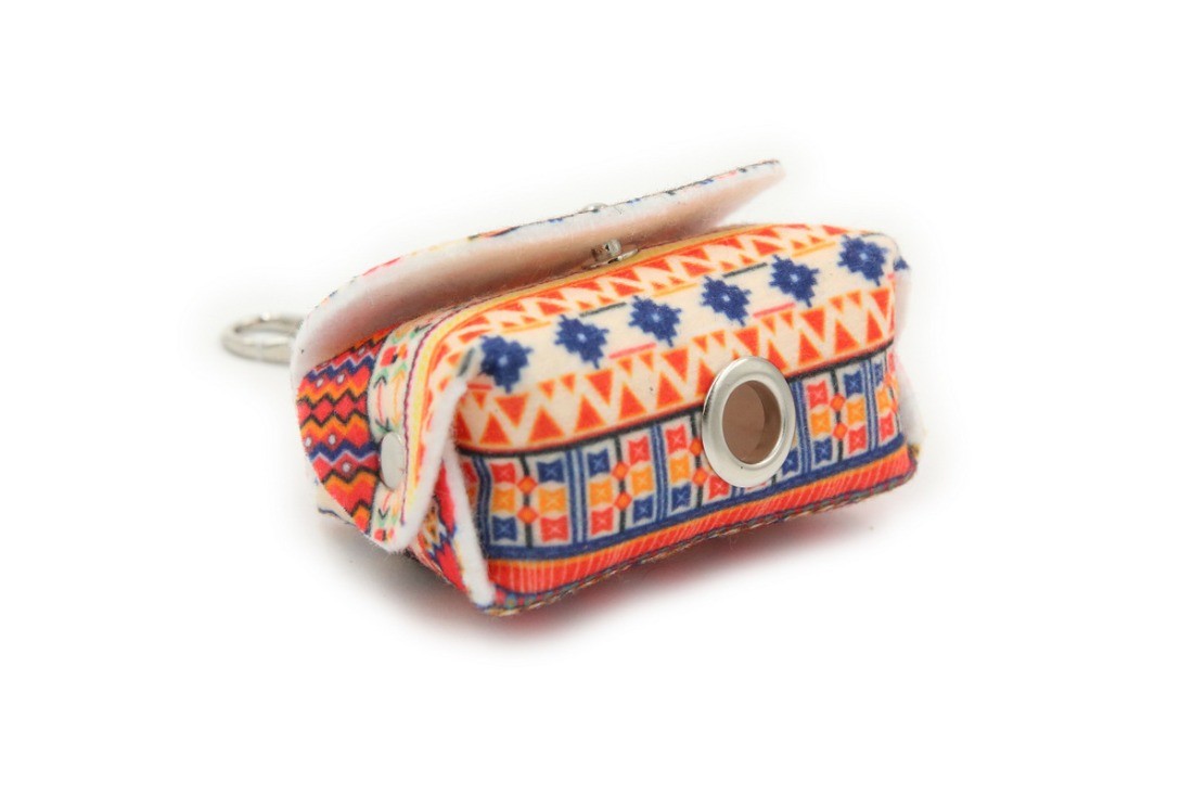 playful boho dog bag dispenser clipped to a leash in golden hour light