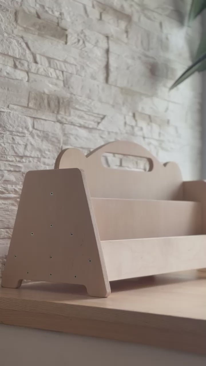 a soft-lit view of the birch bookshelf in a cozy nursery corner, showcasing its gentle height and smooth finish