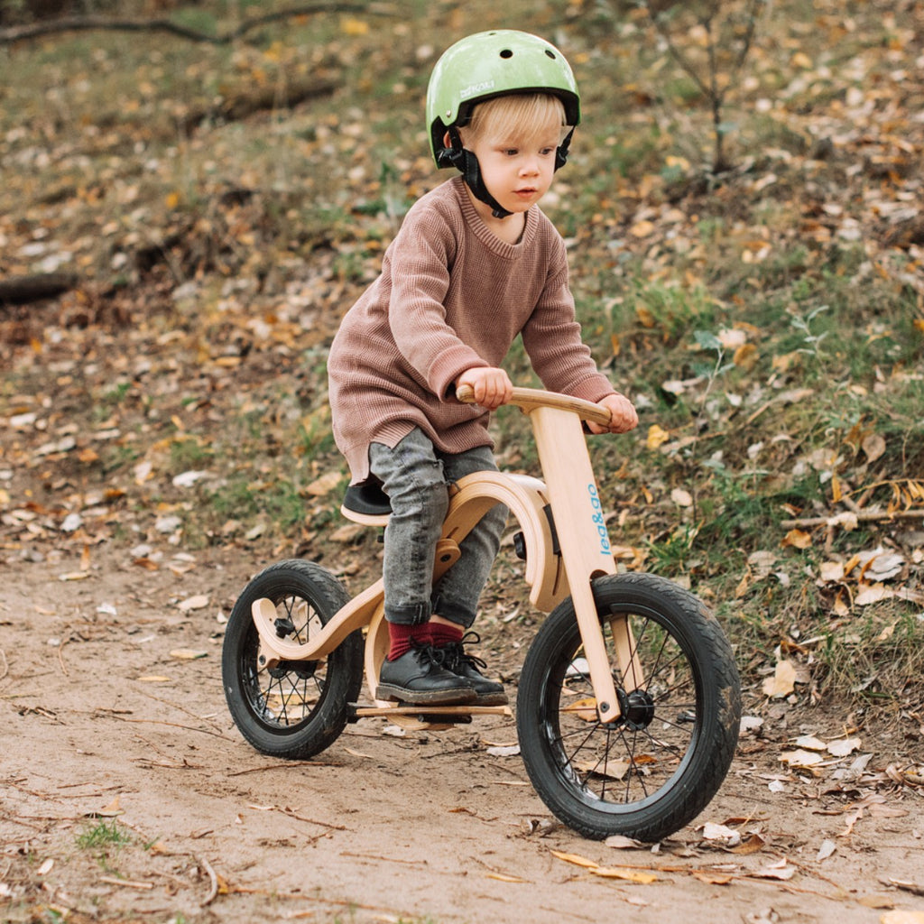 a child's balance bike with a downhill footrest and brake add-on in soft morning light