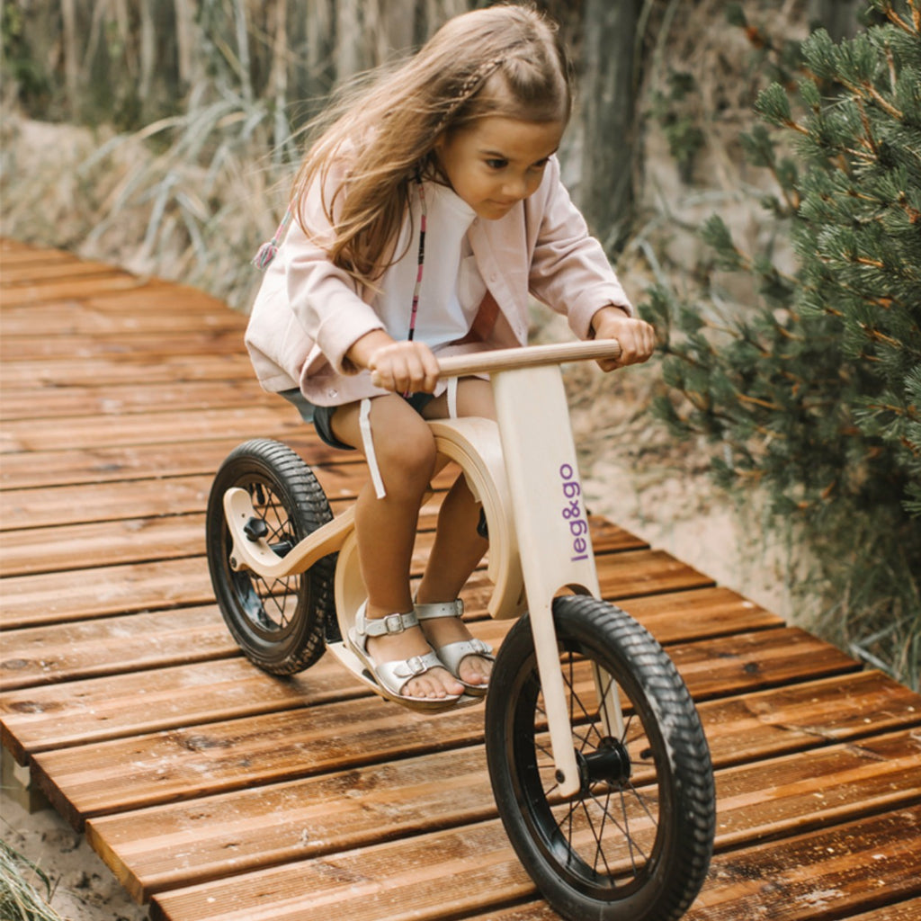 close-up detail of the downhill footrest and brake mechanism on a balance bike