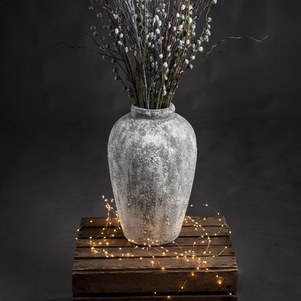 elegant tall ceramic vase with a refined aged stone texture in soft morning light