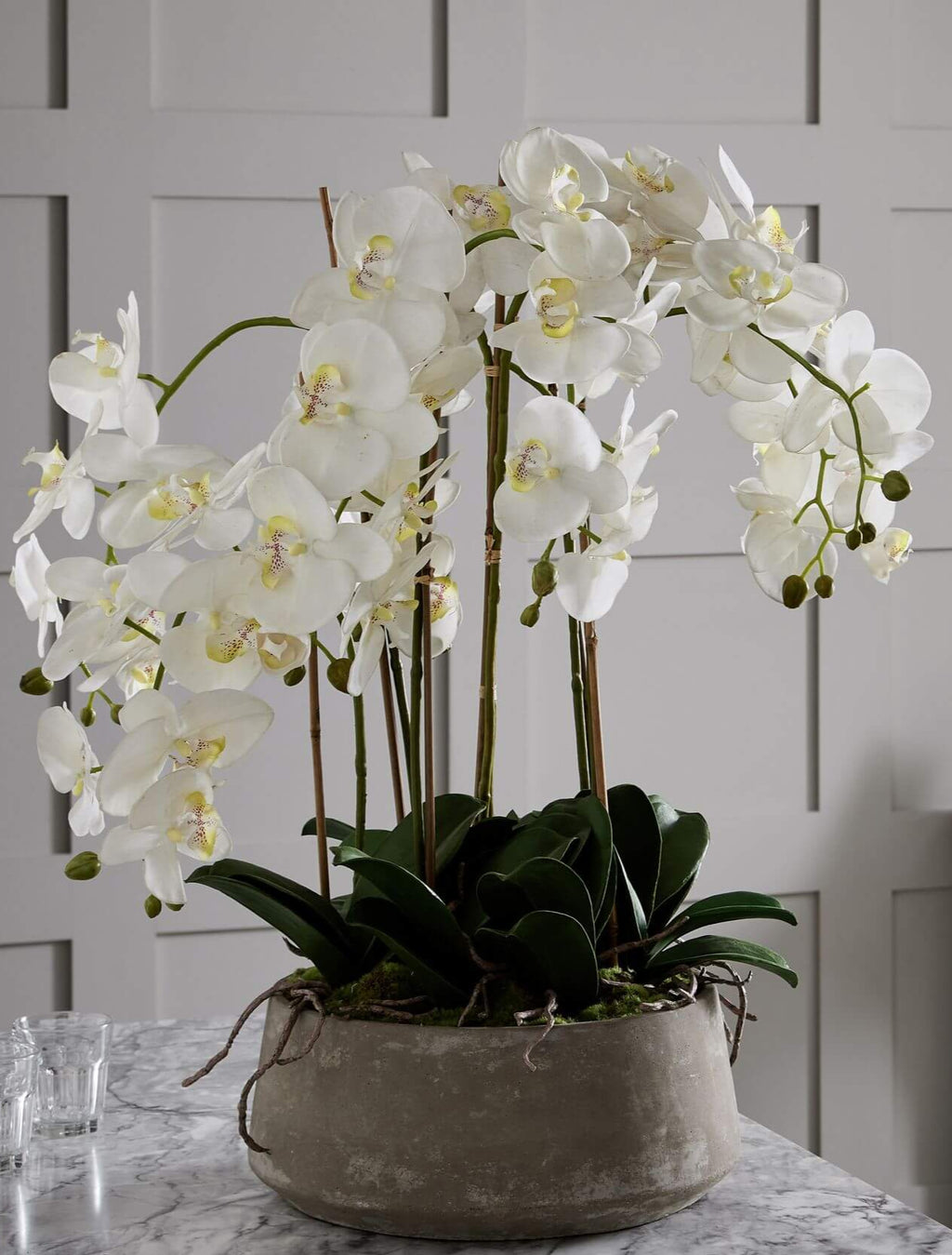 Lifelike white faux orchid in modern stone pot, 90cm tall, realistic plastic blooms with natural stem variations by Sostter at brixbailey.com