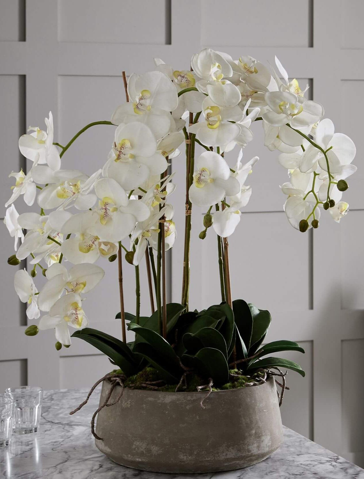 Lifelike white faux orchid in modern stone pot, 90cm tall, realistic plastic blooms with natural stem variations by Sostter at brixbailey.com