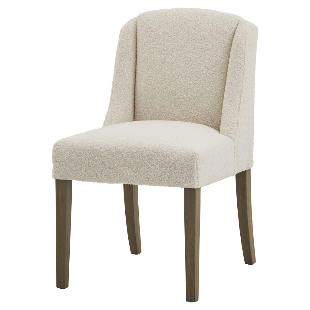 Cream bouclÃ© dining chair with rubberwood frame, modern silhouette, and quiet luxury aesthetic for elegant interiors. by Sostter at brixbailey.com