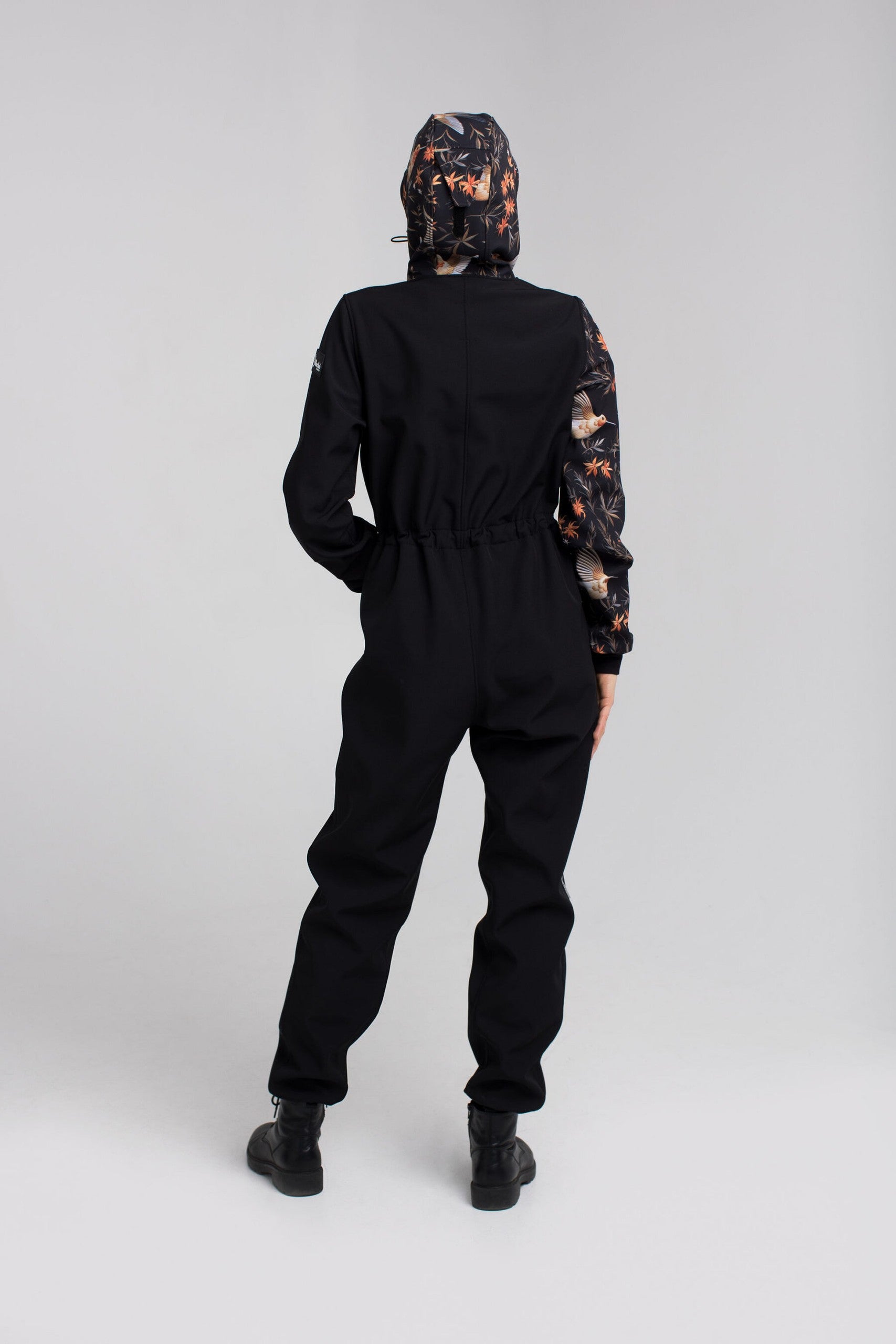 a bold toddler in a stylish waterproof onesie confidently facing the camera in soft morning light