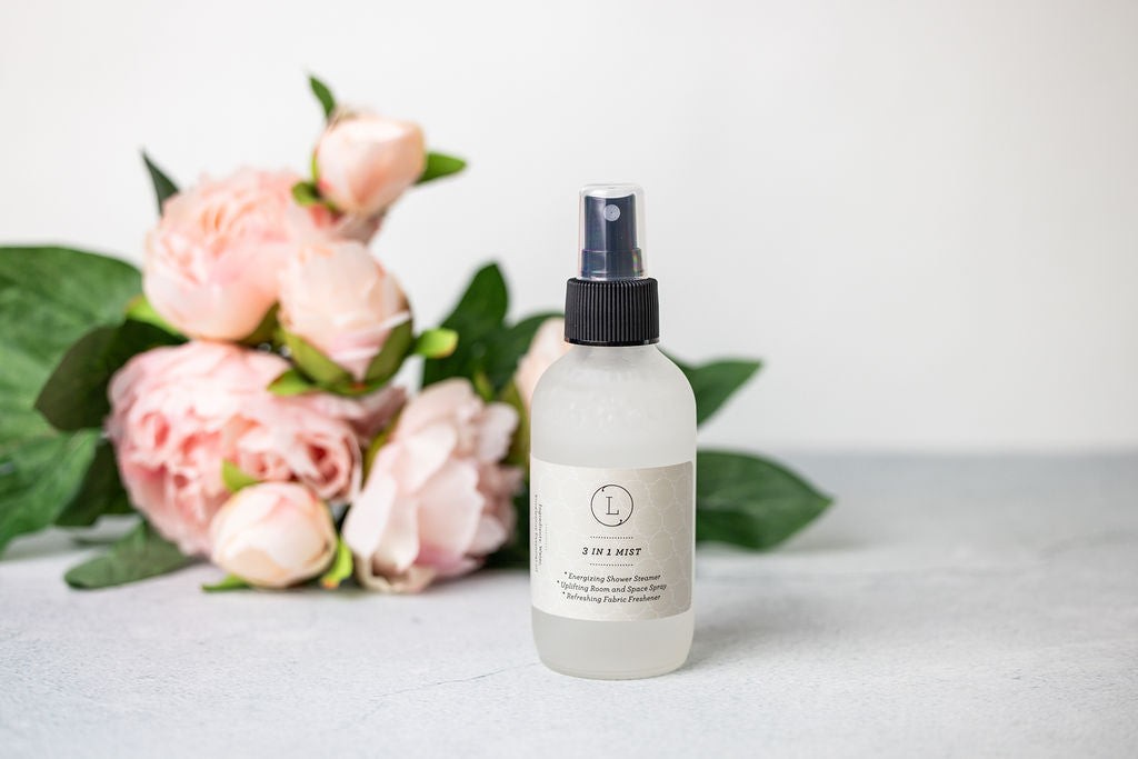 bold close-up of revitalizing eucalyptus room spray in frosted glass bottle with fresh green mist