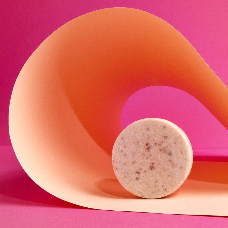 soft pink clay face cleanser bar with gentle foam, resting on a wooden tray with morning light