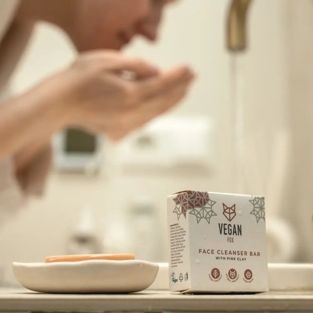 playful pink clay face cleanser bar with orange aroma, foaming gently on a sunny bathroom shelf