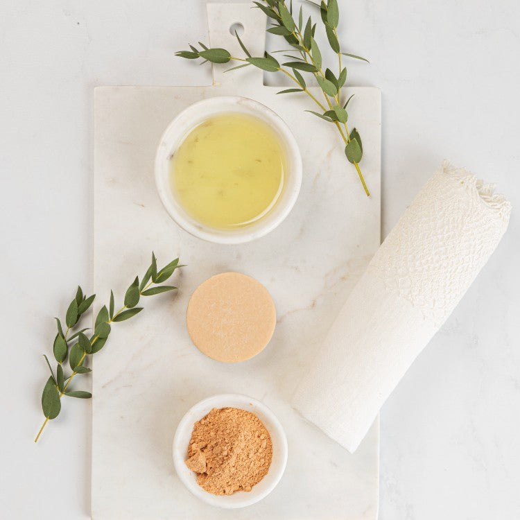 elegant pink clay face cleanser bar with orange aroma, resting on a minimalist marble surface