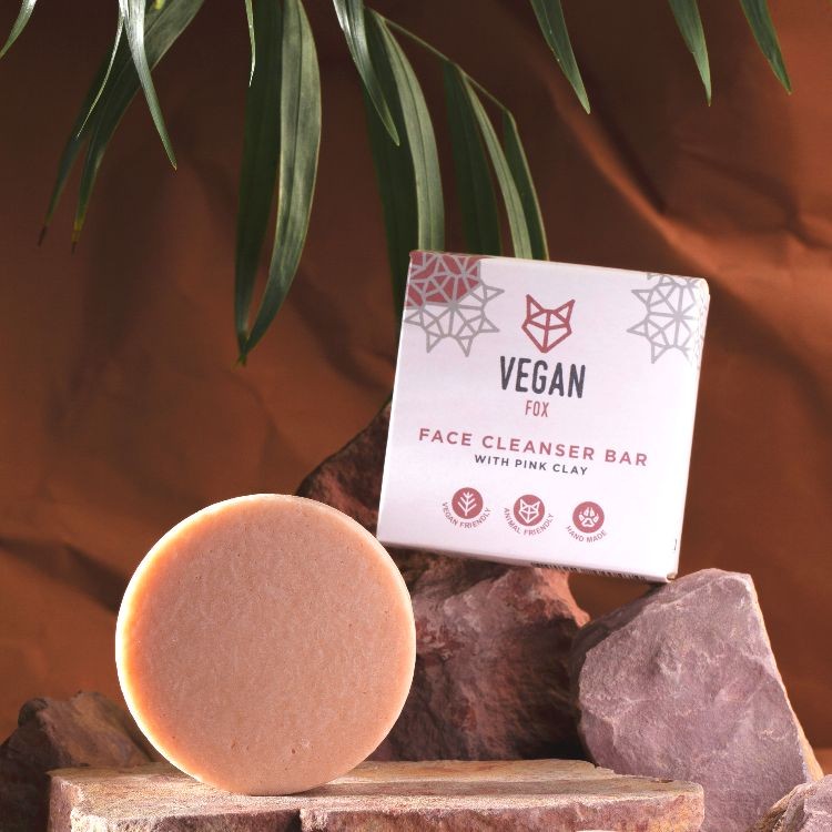 bold pink clay face cleanser bar with orange aroma, vegan and cruelty-free, glowing on marble surface