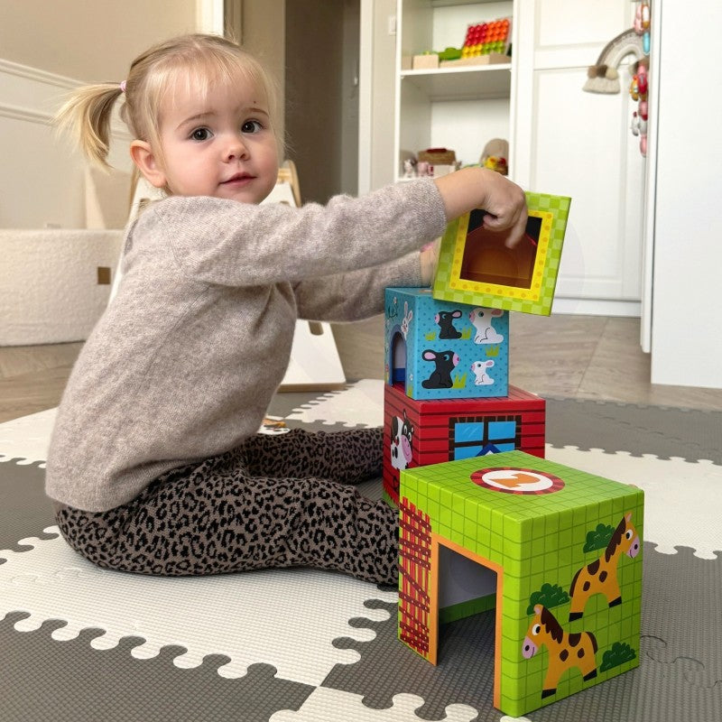 elegant close-up of a child's hand placing a wooden cow into its numbered cube