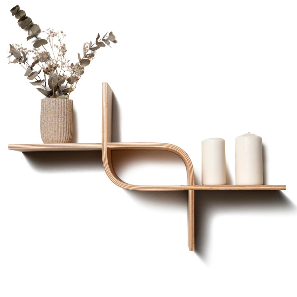 bold walnut curved floating shelf on a dark wall holding a sculptural vase