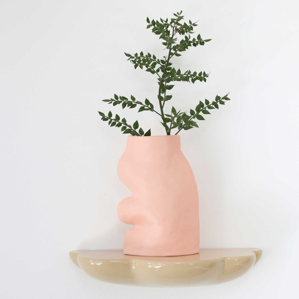 bold pink fluxo ceramic vase on a dark slate table, dramatic lighting highlighting its elegant curves