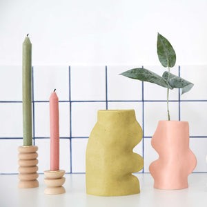 soft pistachio ceramic vase on a cozy tabletop, its gentle curves glowing in warm morning light
