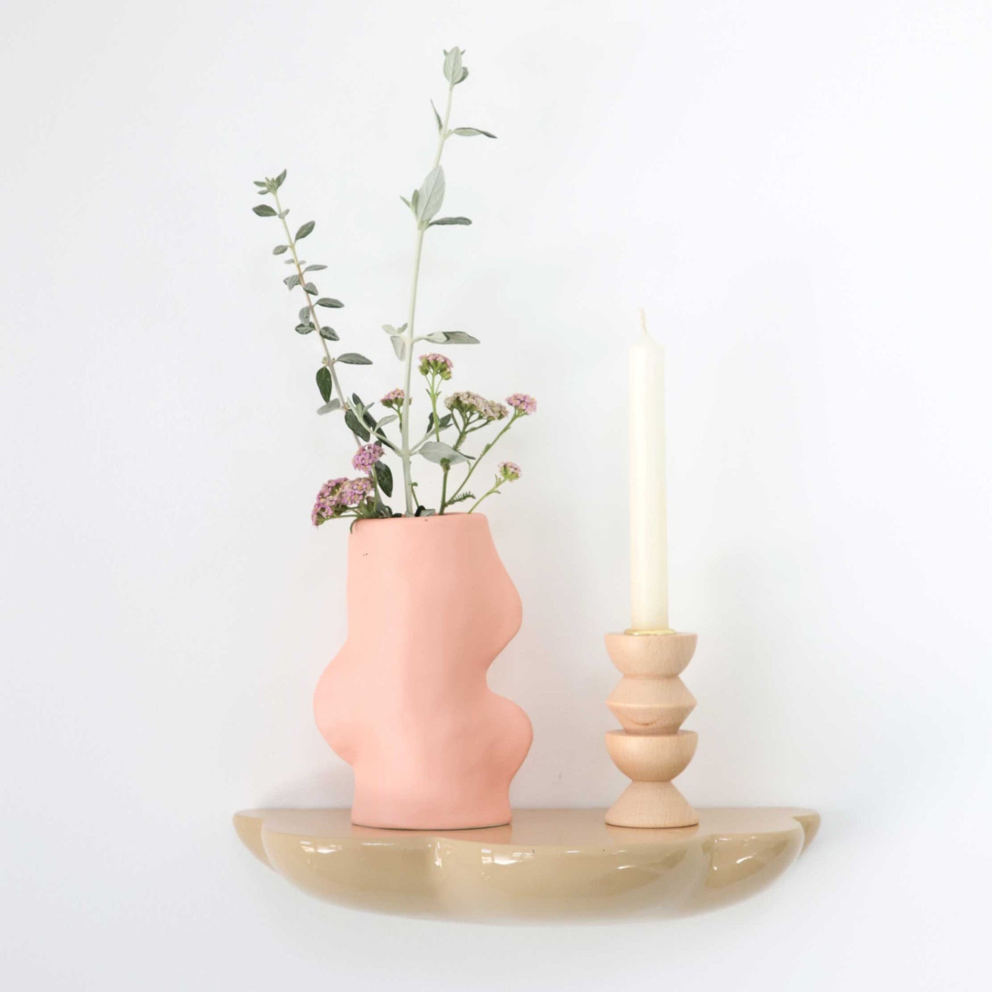 bold pink ceramic fluxo vase on a dark slate surface, dramatic lighting highlighting its fluid handmade form