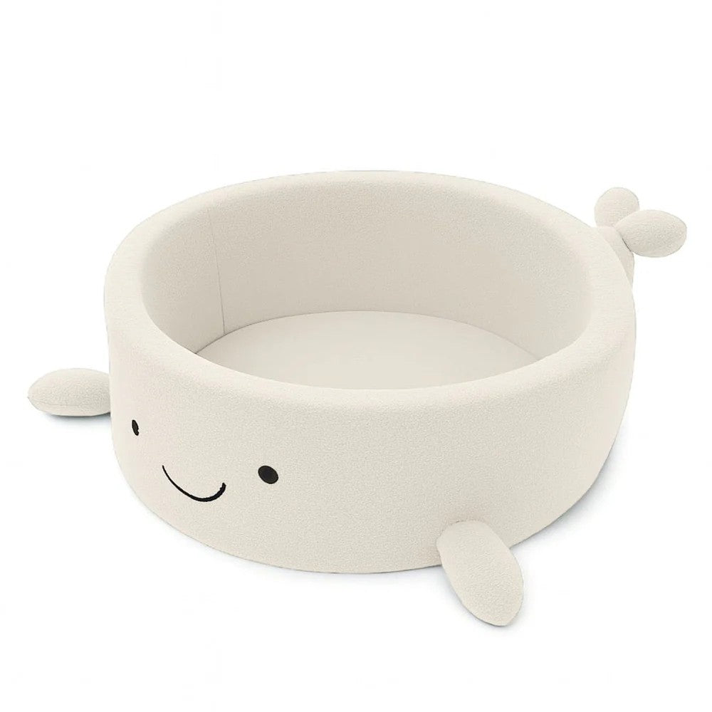 a soft whale boucle ball pit in a cozy nursery, bathed in gentle morning light