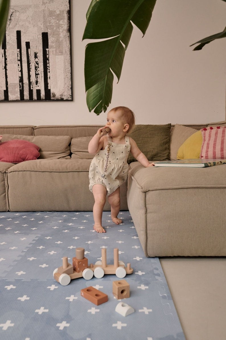 elegant cross azure foam playmat in soft morning light, a sophisticated nursery accent