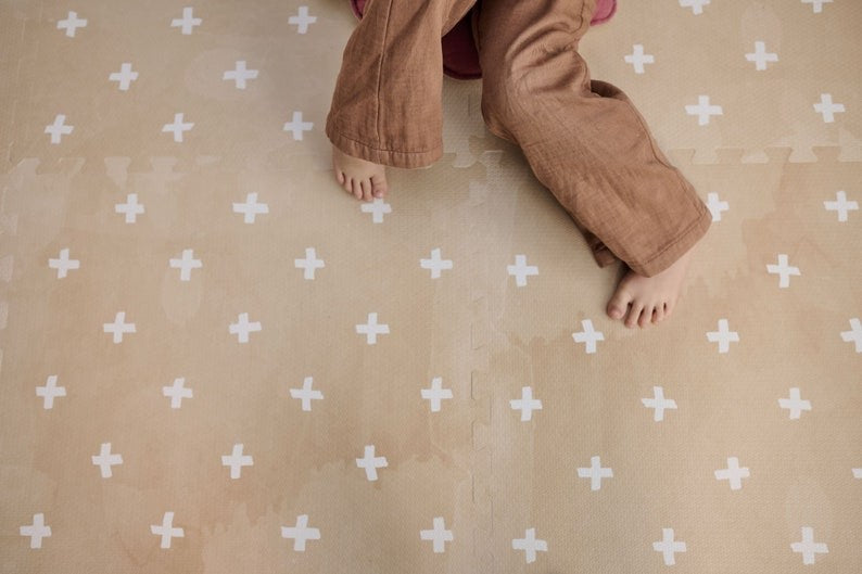 a baby giggling on a soft cross sand foam mat during playful tummy time